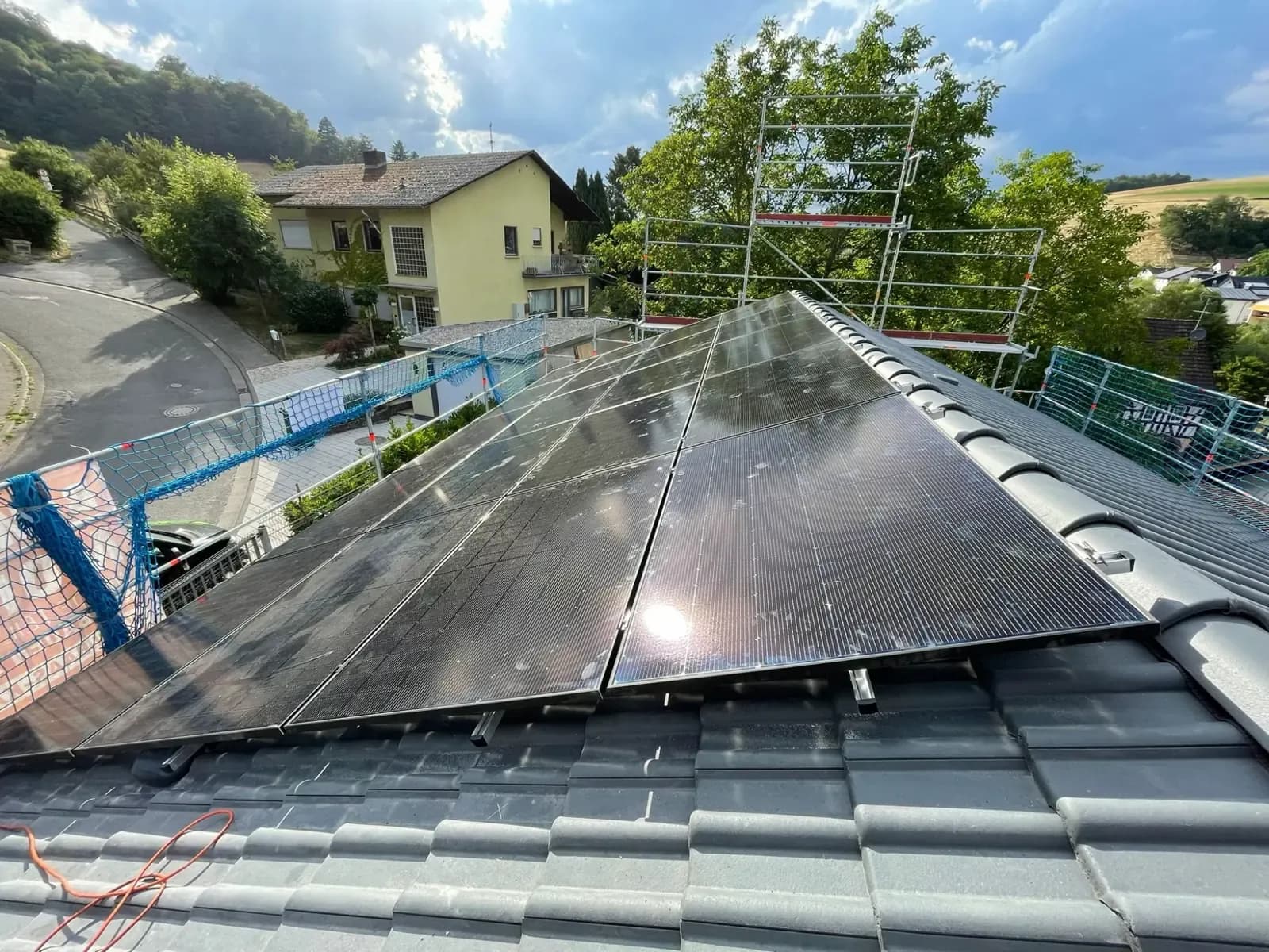 Fertiges Photovoltaik-Modulfeld auf einem Steildach, Blick über den First ins Tal