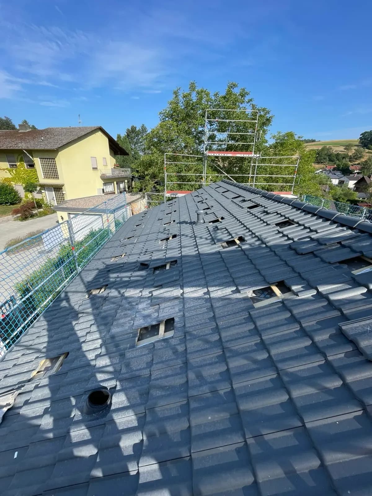 Steildach mit geöffneten Dachpfannen, an denen die Dachhaken für die Unterkonstruktion sitzen