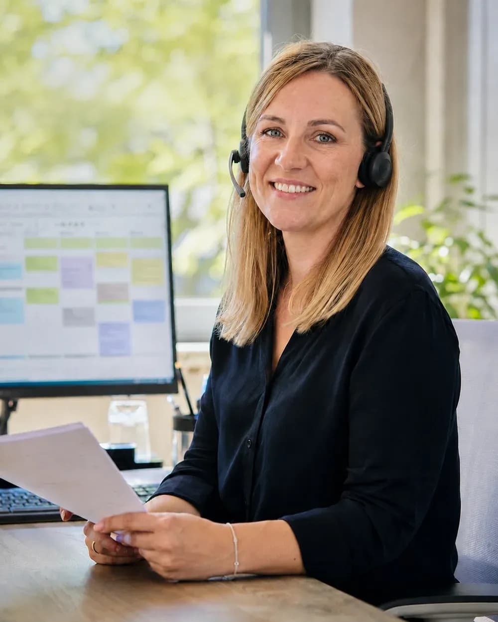 Kristina Reitz, Assistenz der Geschäftsführung bei Solartechnik Odenwald, mit Headset am Schreibtisch