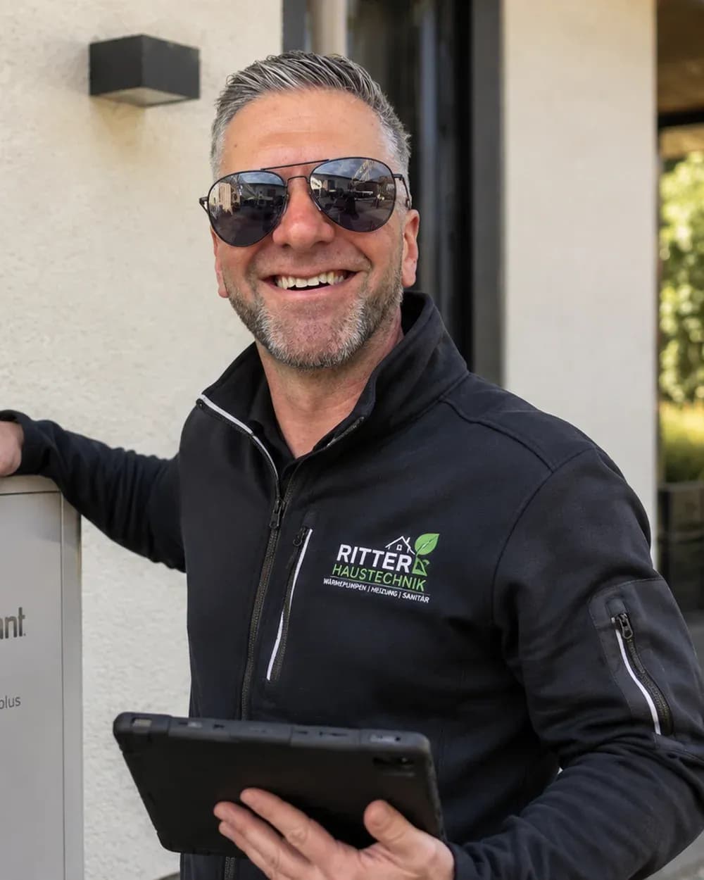 Rudolf Wins, Heizungsinstallateur bei Solartechnik Odenwald, mit einem Tablet neben einer wandmontierten Heizungseinheit